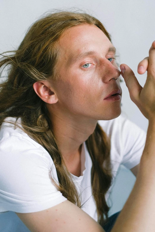 a man brushing his teeth with a toothbrush, an album cover, inspired by Quirijn van Brekelenkam, trending on unsplash, hyperrealism, large eyes and flowing long hair, hannah af klint, holding his hands up to his face, lean man with light tan skin