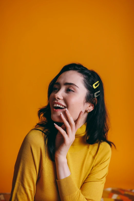 a woman sitting on a bed talking on a cell phone, an album cover, by irakli nadar, trending on pexels, wavy hair yellow theme, maisie williams, happy fashion model face, hands in her hair. side-view