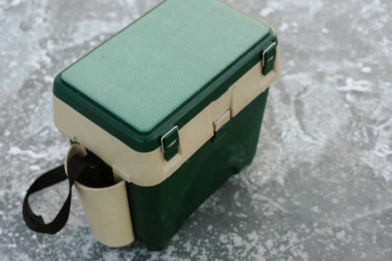 a green and beige cooler sitting on top of a cement floor, inspired by Rachel Whiteread, unsplash, fishing, school bag, holds playing cards, high quality photo