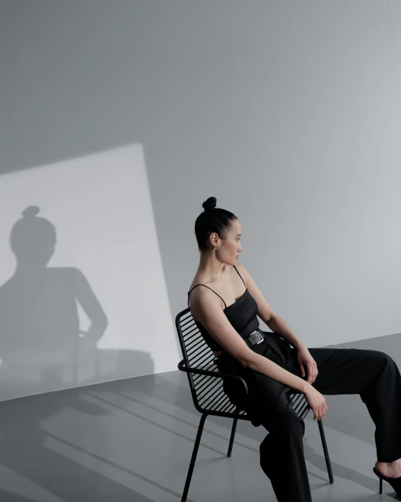 a woman sitting on a chair in a room, inspired by Fei Danxu, light and space, dynamic shadow, non binary model, instagram picture, portrait featured on unsplash