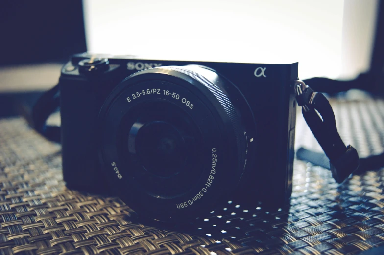 a black camera sitting on top of a table, by Carey Morris, unsplash, photorealism, sony a 6 3 0 0, !!! shallow depth of field!!!, a portrait of @hypnos_onc, ((photorealistic))