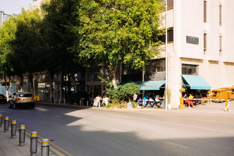a street filled with lots of traffic next to tall buildings, ashcan school, sitting in a cafe, cyprus, foliage, ignant