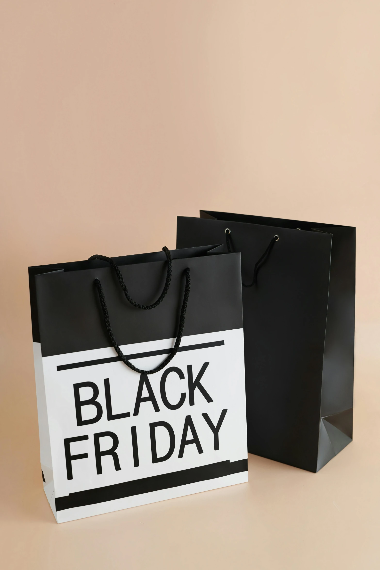 a black friday shopping bag on a beige background, by Adam Saks, happening, large format, f/8, white on black, holiday