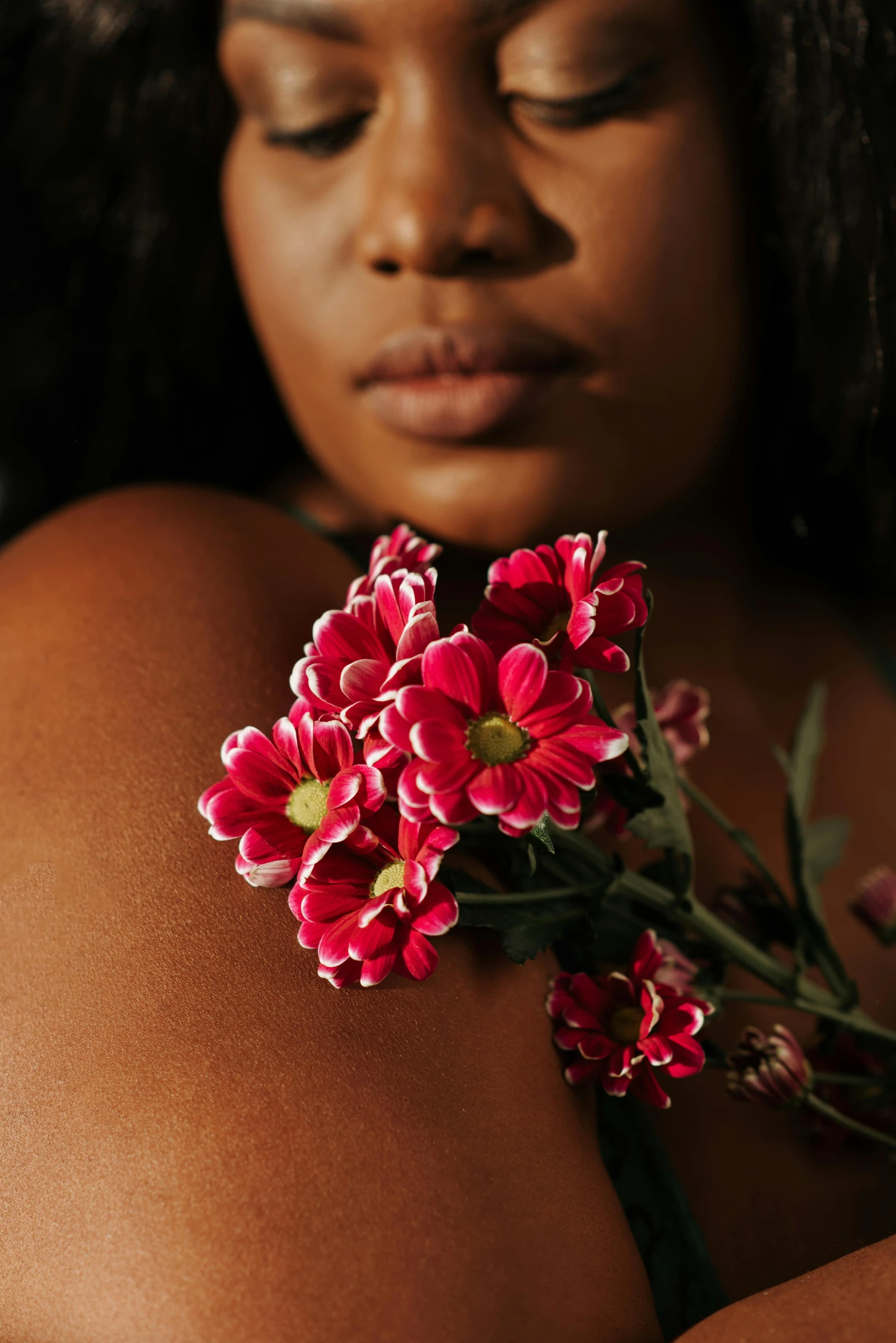 a close up of a person holding a flower, an album cover, by Cosmo Alexander, trending on unsplash, renaissance, alluring plus sized model, dark brown skin, red and white flowers, arm around her neck