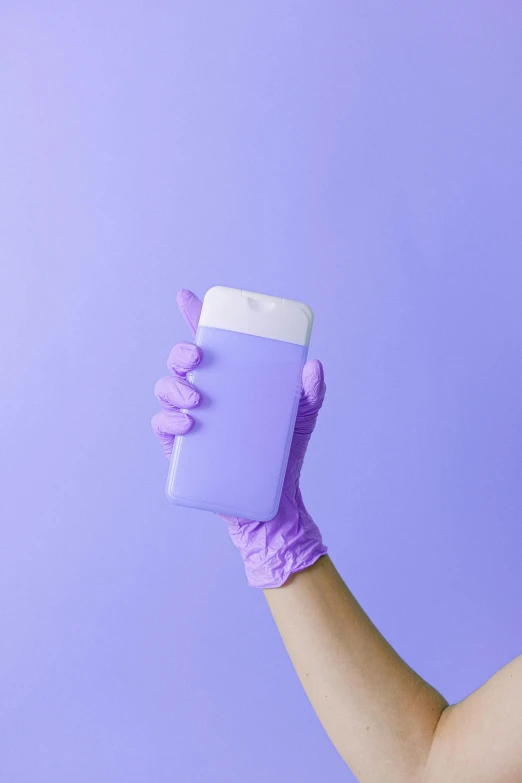 a woman in purple gloves holding a bottle of hand sanitizer, inspired by Yves Klein, trending on pexels, color field, pastel blue, cellphone, surgeon, rectangle