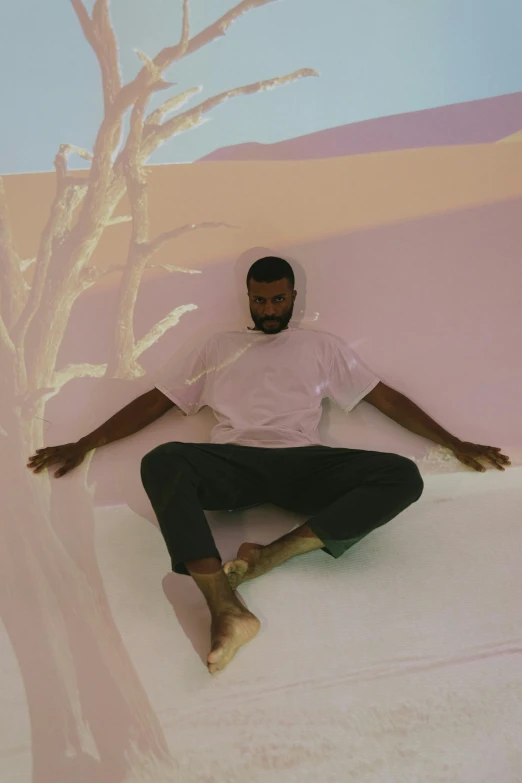 a man sitting on top of a snowboard next to a tree, an album cover, pexels contest winner, magic realism, kanye west torso, sitting across the room, petra collins, meditating pose