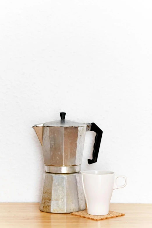 a coffee pot sitting on top of a wooden table next to a cup, by Carey Morris, minimalism, - 9, game ready, digital image, aluminum