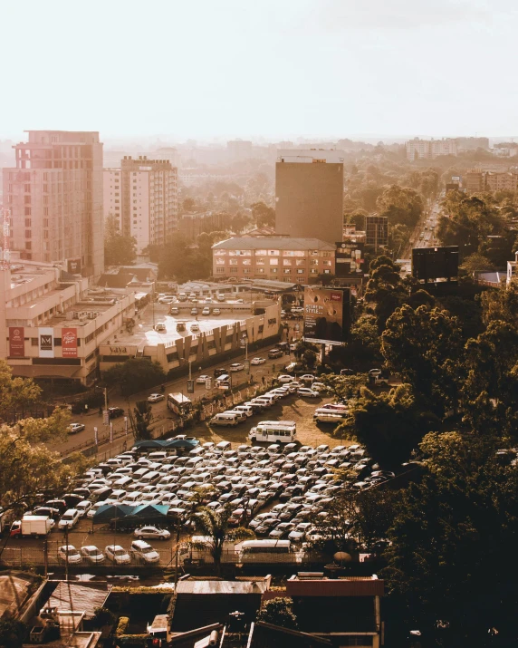 a parking lot filled with lots of parked cars, trending on unsplash, happening, cairo, city buildings on top of trees, lgbtq, unmistakably kenyan