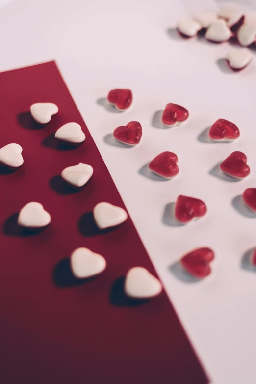 a table topped with lots of red and white hearts, pexels, gumdrops, two - tone, 10k, maroon
