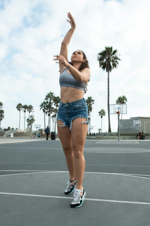 a woman standing on top of a tennis court holding a racquet, by Josh Bayer, arabesque, playing basketball, wearing a tank top and shorts, mia khalifa, oceanside