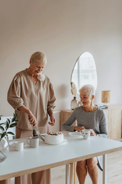 a couple of people that are sitting at a table, cake, white haired lady, minimal kitchen, profile image