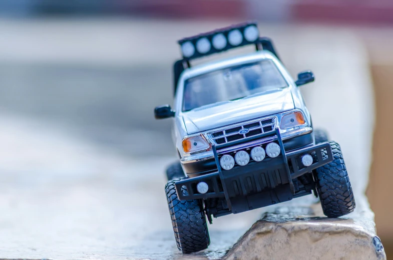 a toy truck sitting on top of a rock, unsplash, photorealism, car jump, with a roof rack, avatar image, action sports