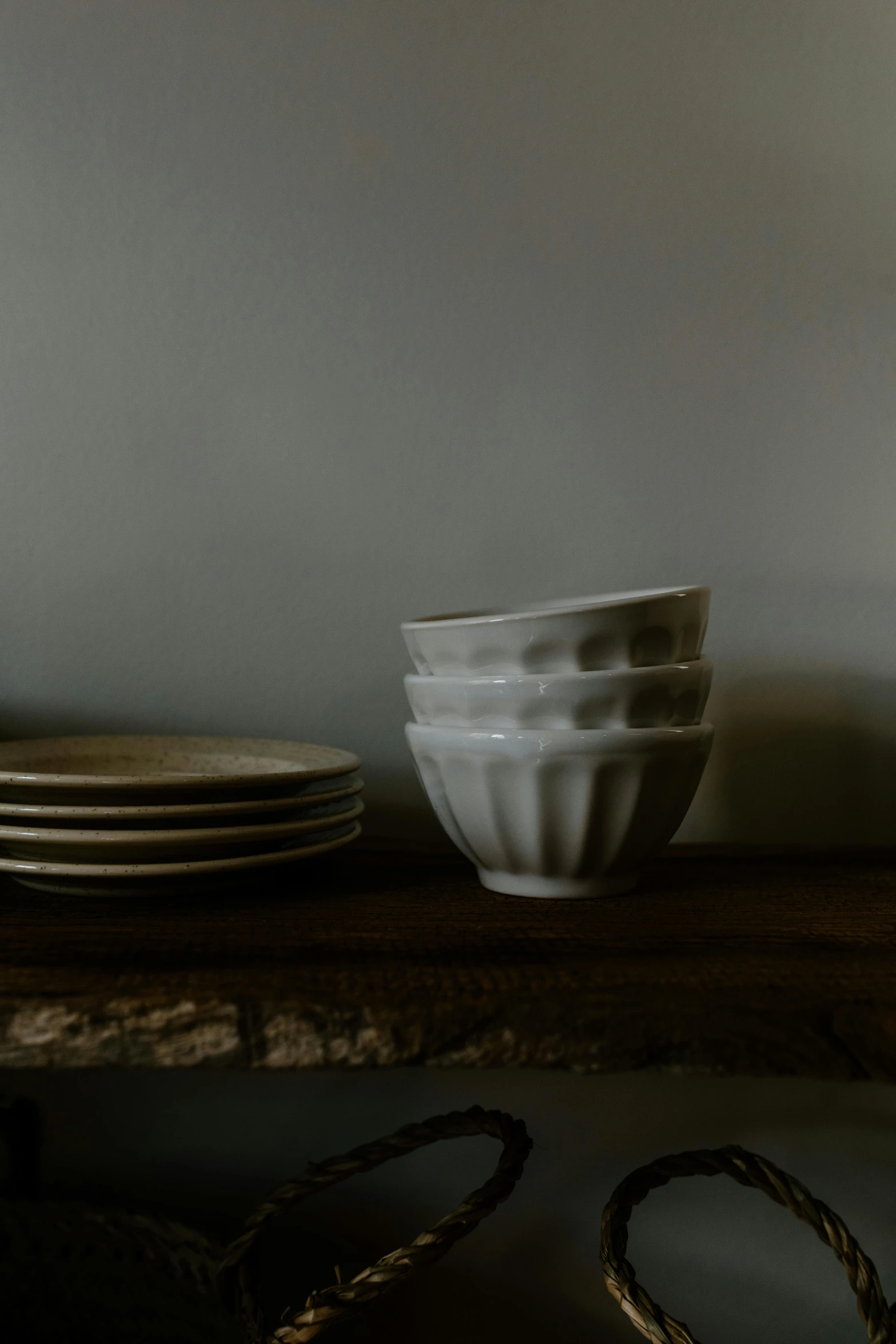 a stack of plates sitting on top of a wooden table, a still life, inspired by Lewis Henry Meakin, unsplash, renaissance, bowl, beautiful sculpted details, soft light from the side, in a row