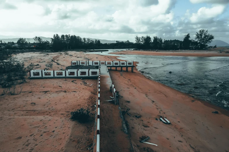 a train traveling along a sandy beach next to a body of water, inspired by Simon Stalenhag, unsplash contest winner, hurufiyya, sewage, red sand, near a jetty, monsoon on tropical island