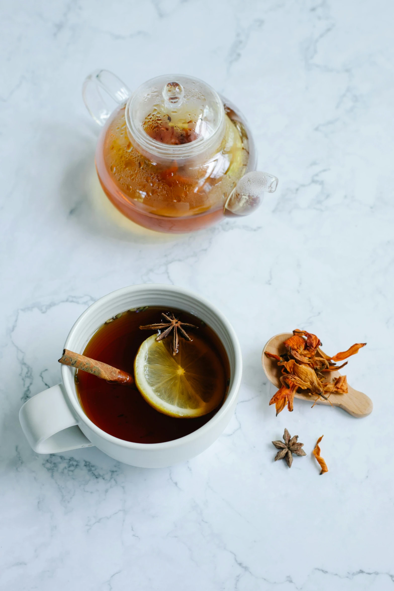 a cup of tea and a teapot on a table, inspired by Wlodzimierz Tetmajer, trending on pexels, spices, square, on grey background, marmalade