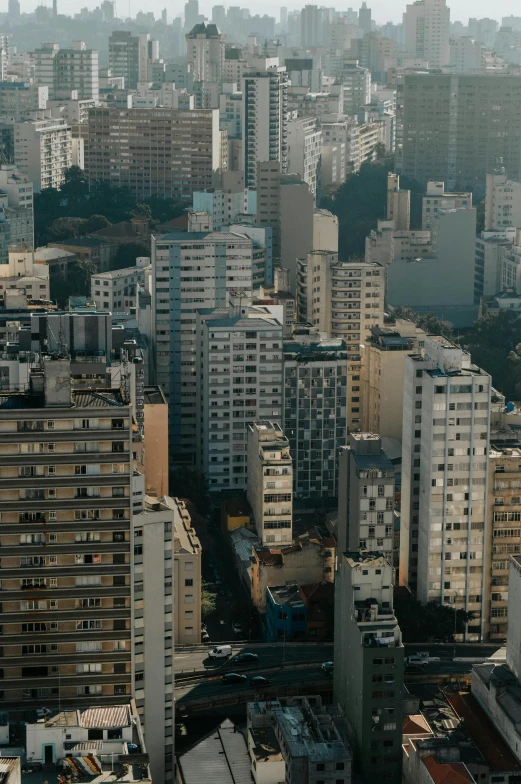 a view of a city from the top of a building, by Elsa Bleda, trending on unsplash, brutalism, brazil, stacked houses, panoramic widescreen view, late afternoon