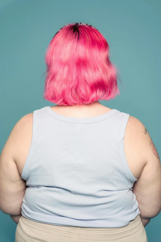 a woman with pink hair standing in front of a blue wall, morbidly obese, rear view, ((pink)), wearing : tanktop