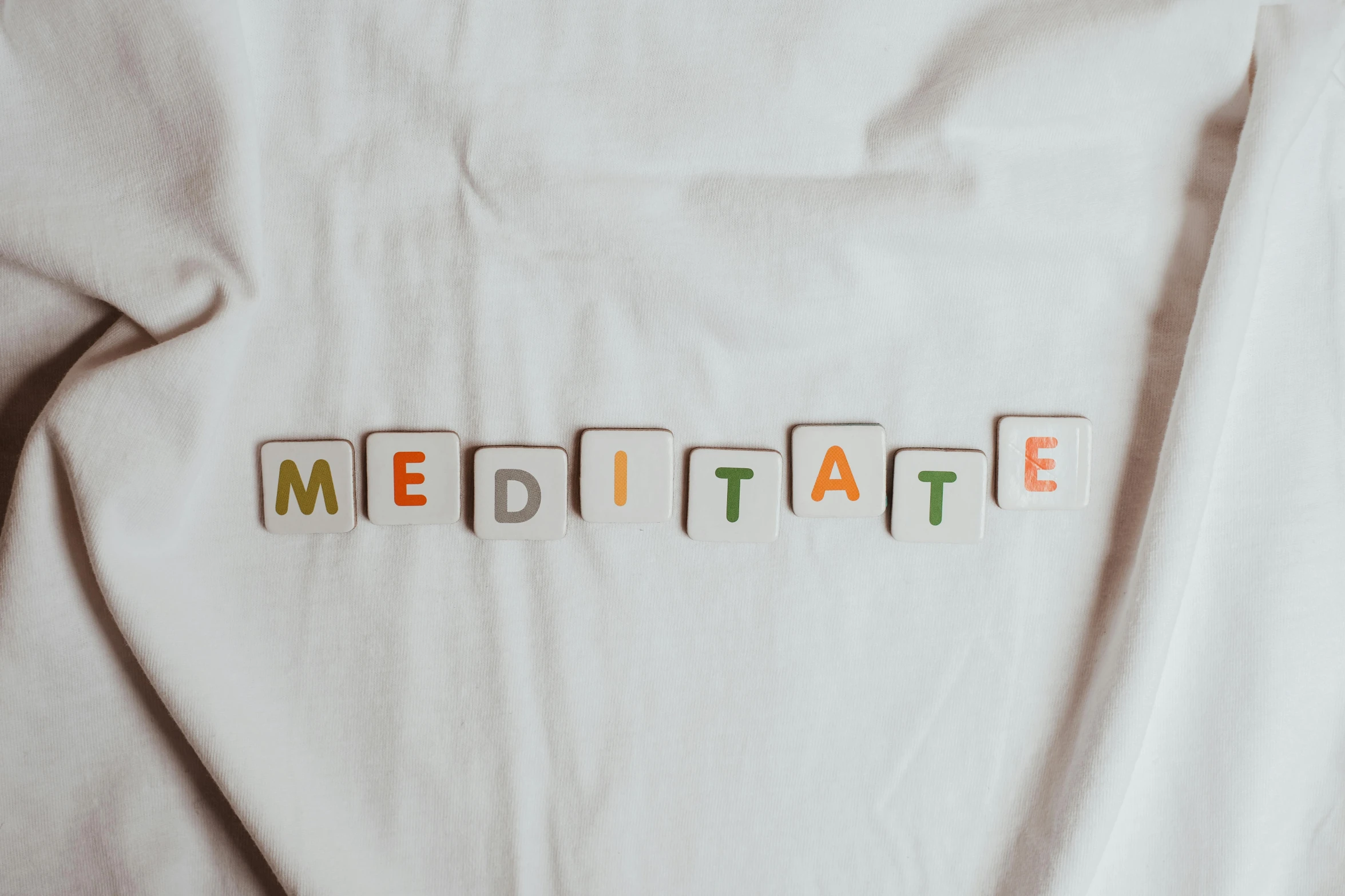 a white shirt with the word meditate written on it, trending on pexels, private press, repeating, health spa and meditation center, made of glazed, 1 2 9 7