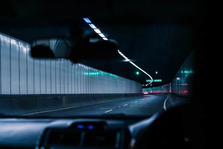 a car driving through a tunnel at night, unsplash, panoramic anamorphic, shot on sony a 7, neon reflections, nightlife