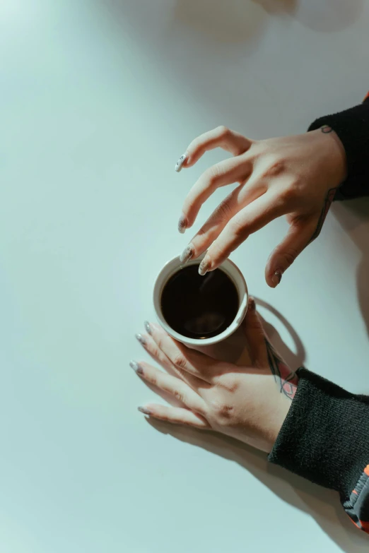 a close up of a person holding a cup of coffee, inspired by Elsa Bleda, trending on pexels, minimalism, unclipped fingernails, reaching out to each other, dark. no text, long coffee brown hair