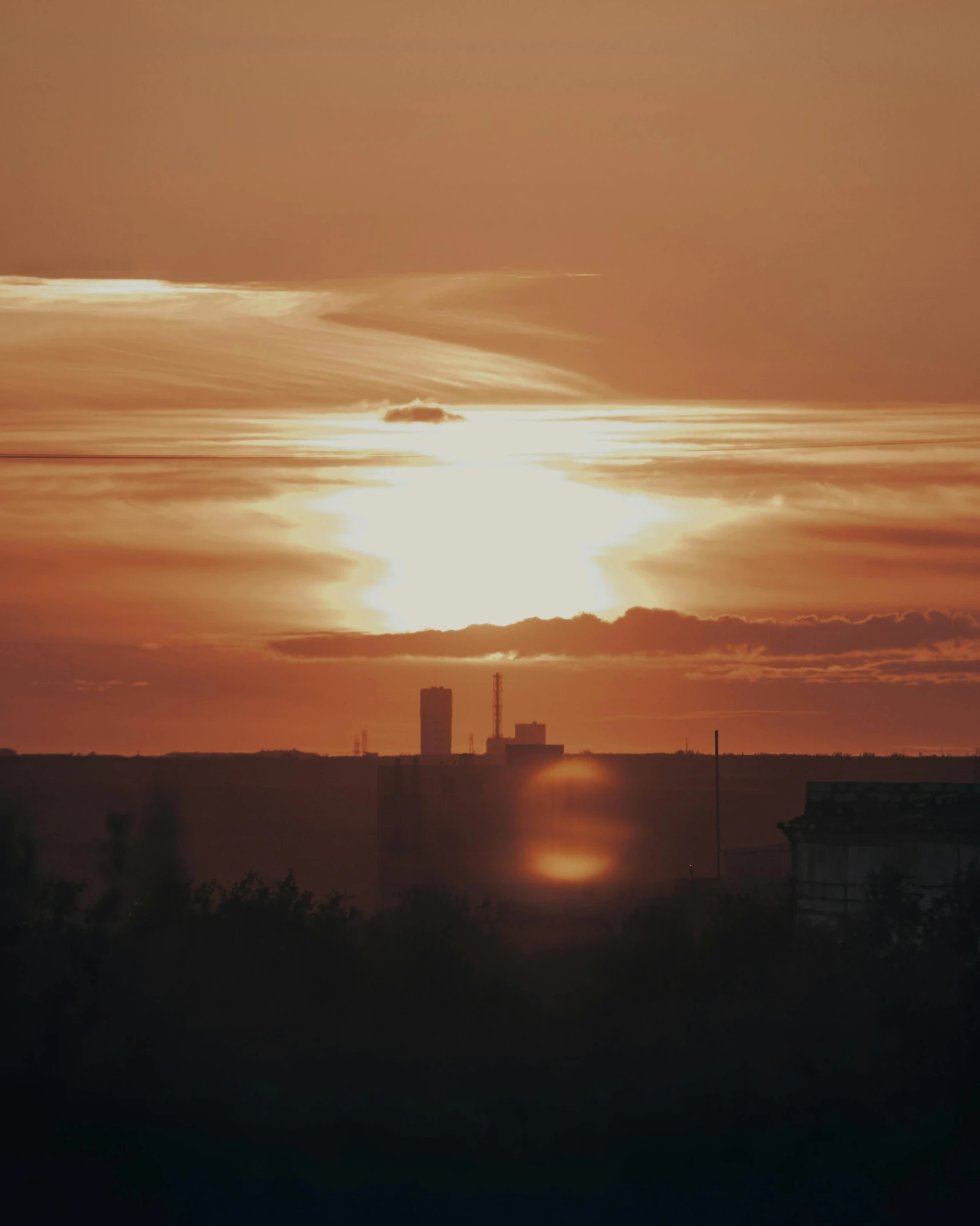 a picture of the sun setting over a city, by Attila Meszlenyi, happening, low quality photo, helsinki, sky is orangish outside, apocalyptic setting