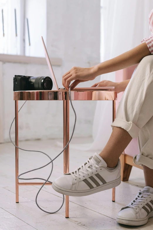 a woman sitting on a chair using a laptop, inspired by Sarah Lucas, trending on pexels, wires made of copper, sneaker photo, usb ports, glossy white metal