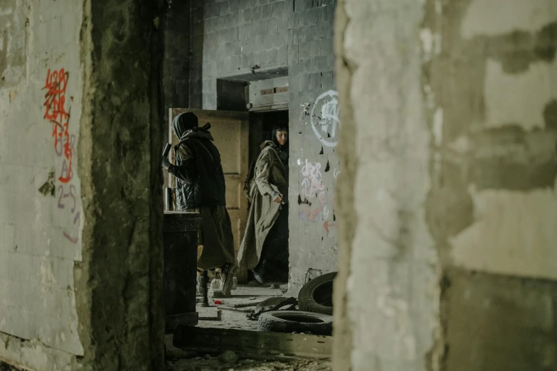 a couple of men standing inside of a building, dirty walls, hunting, production still, enes dirig