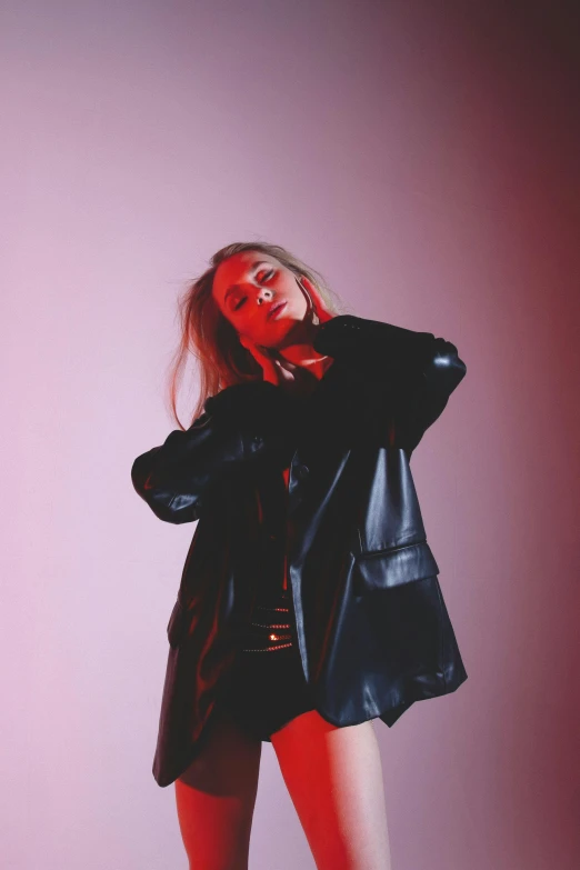 a woman in a black jacket and red tights, an album cover, inspired by Elsa Bleda, unsplash, leather robes, profile image, blonde, in a photo studio