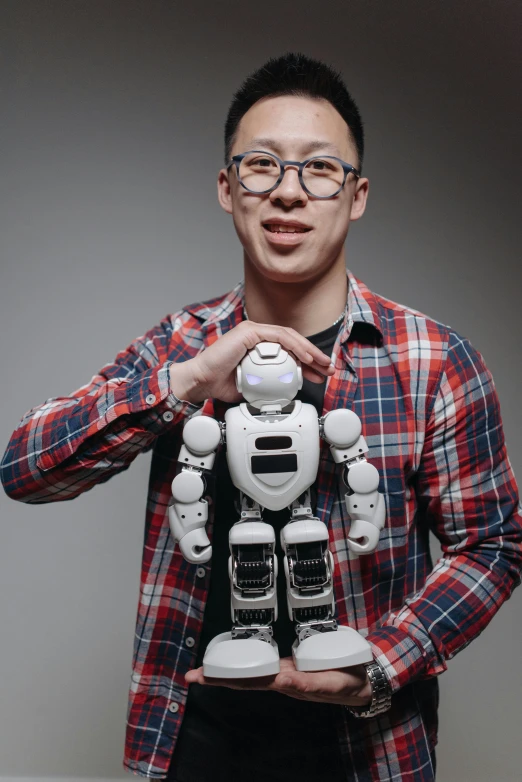 a man in a plaid shirt holding a robot, inspired by Feng Zhu, photo taken in 2 0 2 0, portrait shot, peter chan, demur