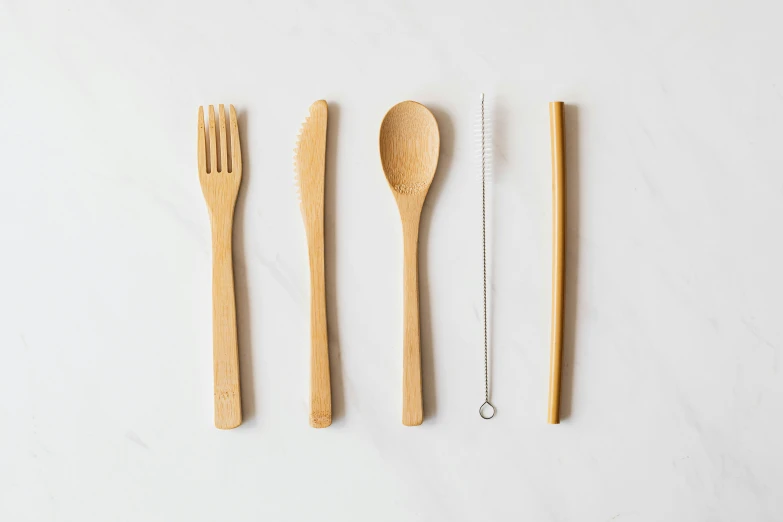 a group of wooden utensils sitting next to each other, food, with a straw, black fork, flatlay