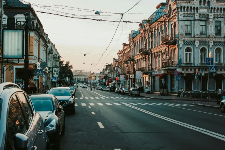 a street filled with lots of traffic next to tall buildings, a photo, by Alexander Runciman, pexels contest winner, renaissance, rostov city, early morning light, busy small town street, neoclassical style