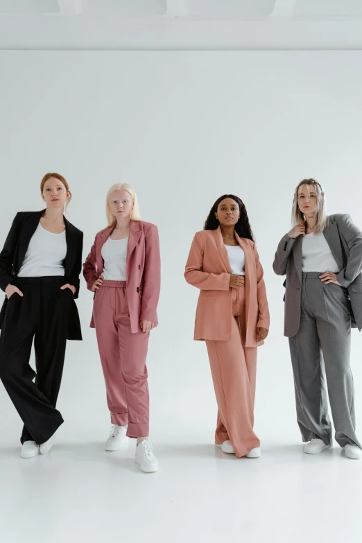 a group of women standing next to each other, trending on pexels, grey suit, set against a white background, federation clothing, large tall