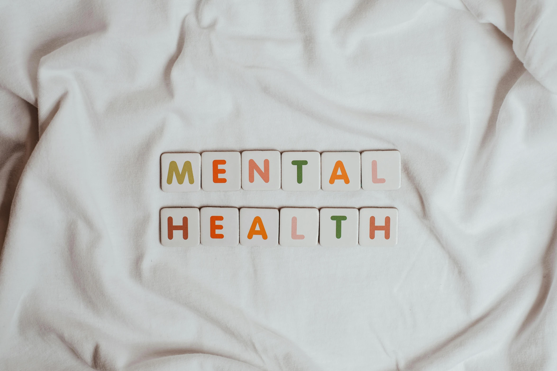 a white t - shirt with the words mental health written on it, a cartoon, by Emma Andijewska, trending on pexels, antipodeans, wide high angle view, multi - coloured, on a pale background, digital oth