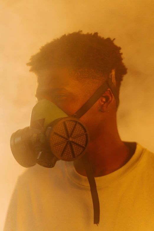 a man wearing a yellow shirt and a gas mask, by Frank Mason, pexels, afrofuturism, smoke fills the room, 2 1 savage, teddy fresh, covered in dust