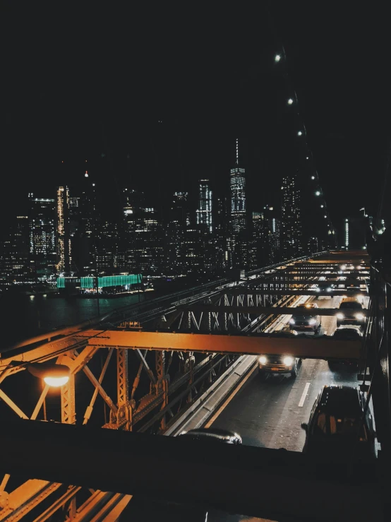 a view of a city at night from the top of a bridge, an album cover, pexels contest winner, trending on vsco, nyc, high quality photo, industrial aesthetic