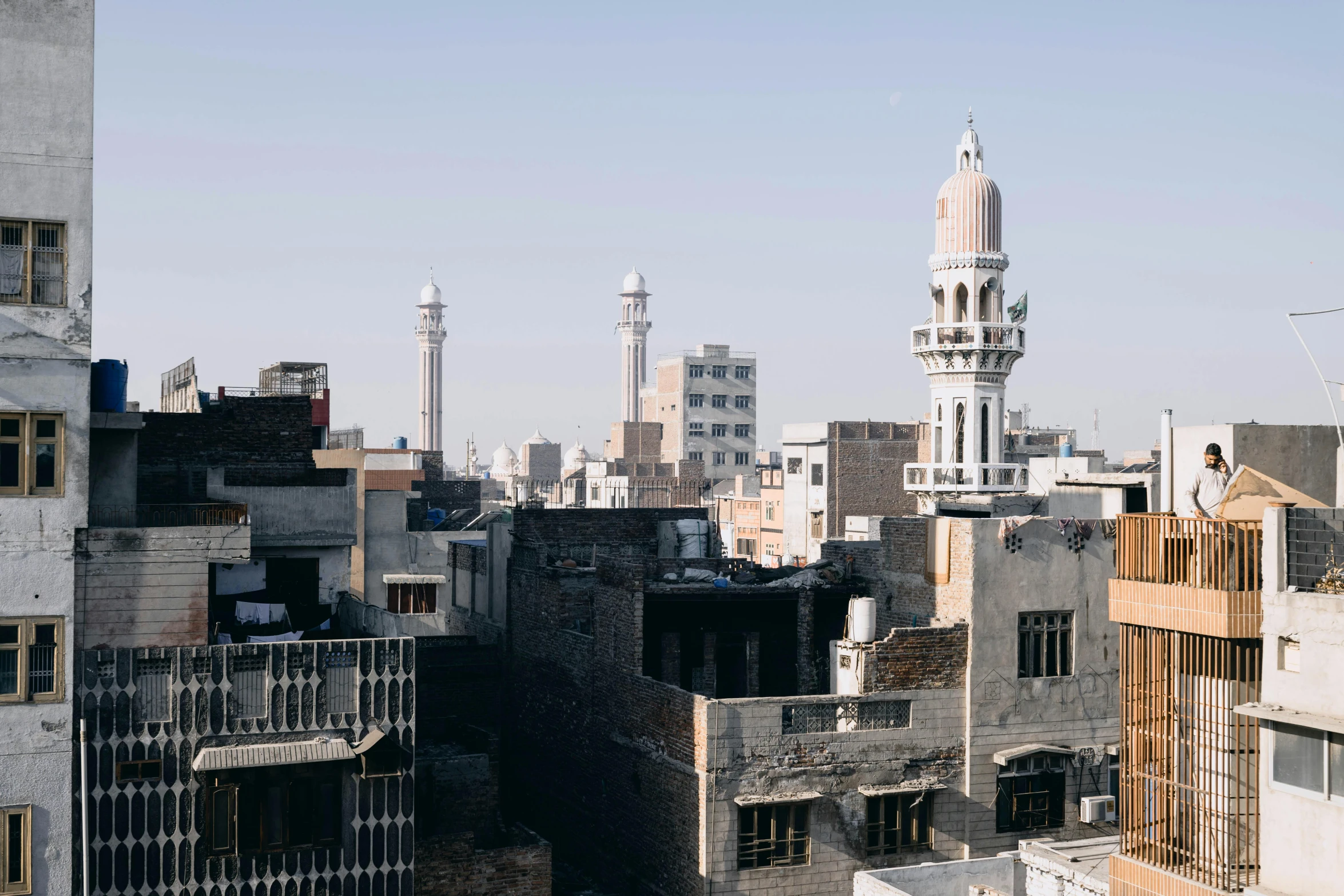 a view of a city from the top of a building, minarets, karachi skyline background, dezeen, jen atkin