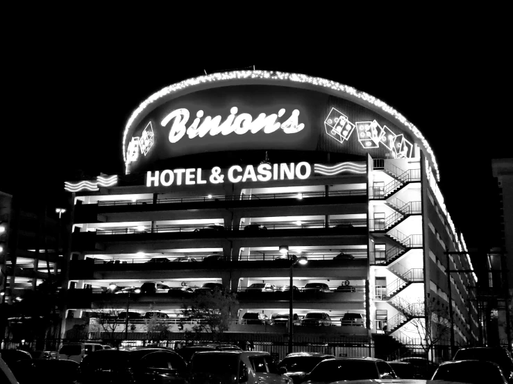 a black and white photo of a hotel and casino, a black and white photo, by Ben Thompson, optical illusion, 🌻🎹🎼, pistons, night life, shot on nicon camera