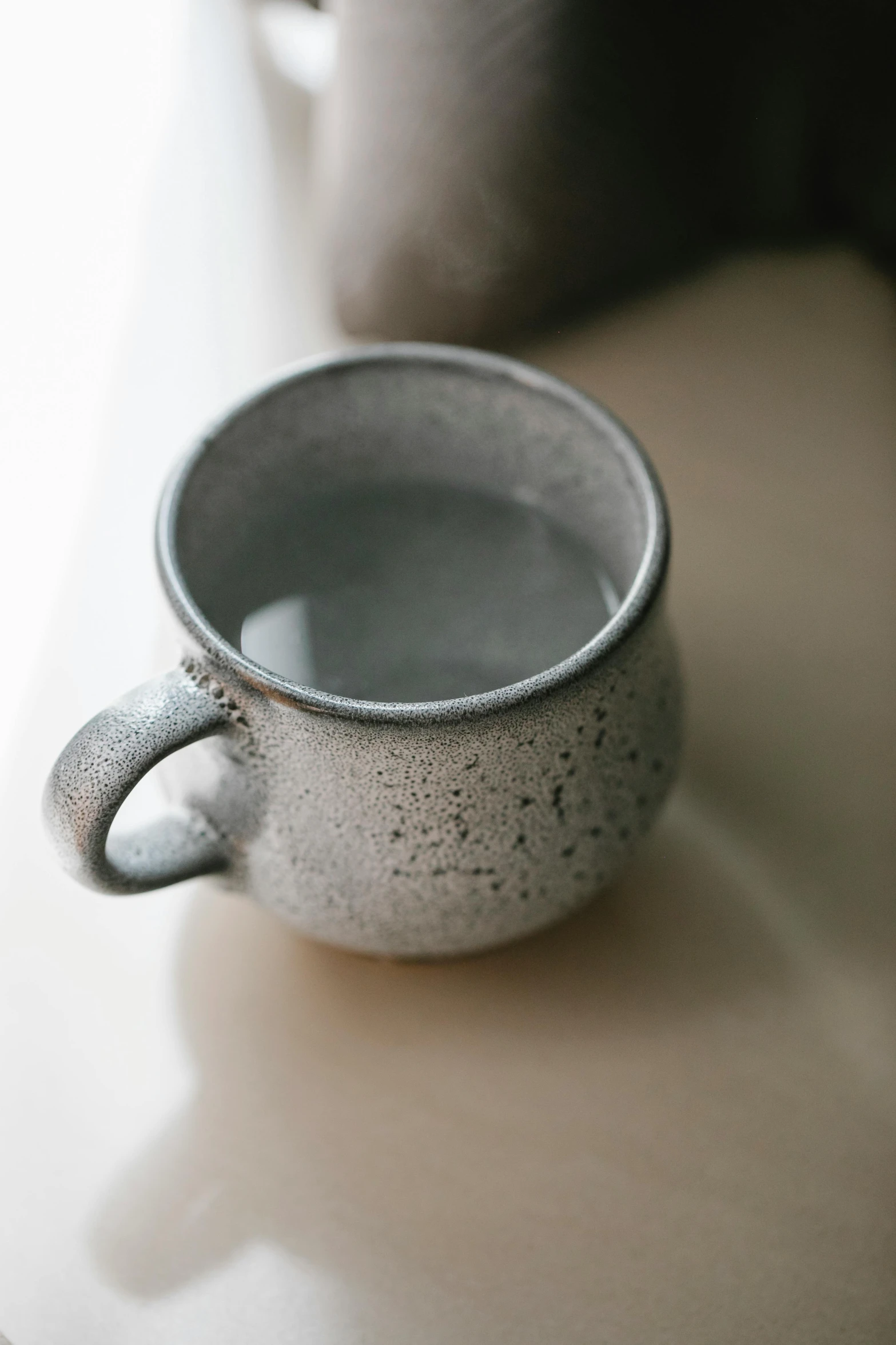 a close up of a cup on a table, light grey mist, glazed, sweaty, kettle