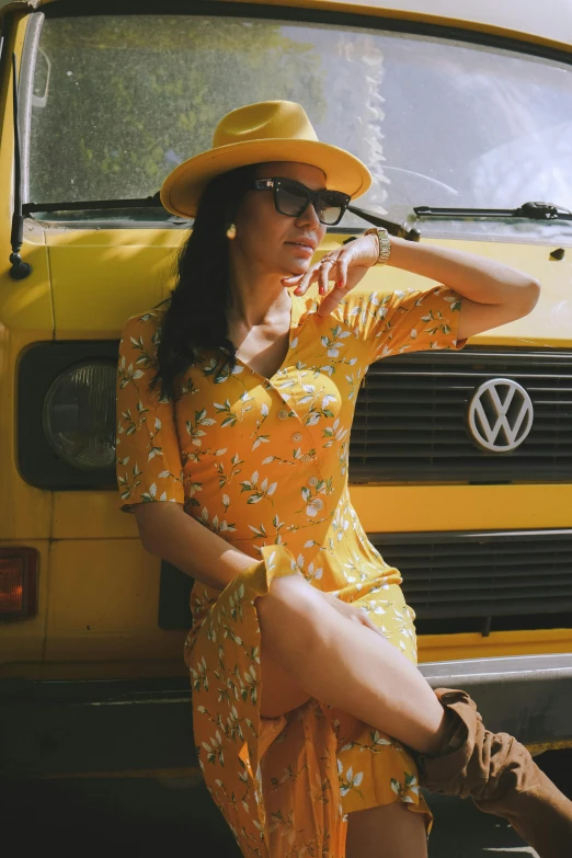 a woman in a yellow dress and hat leaning against a yellow van, pexels contest winner, kombi, dressed in a flower dress, square, wearing sunglasses and a hat