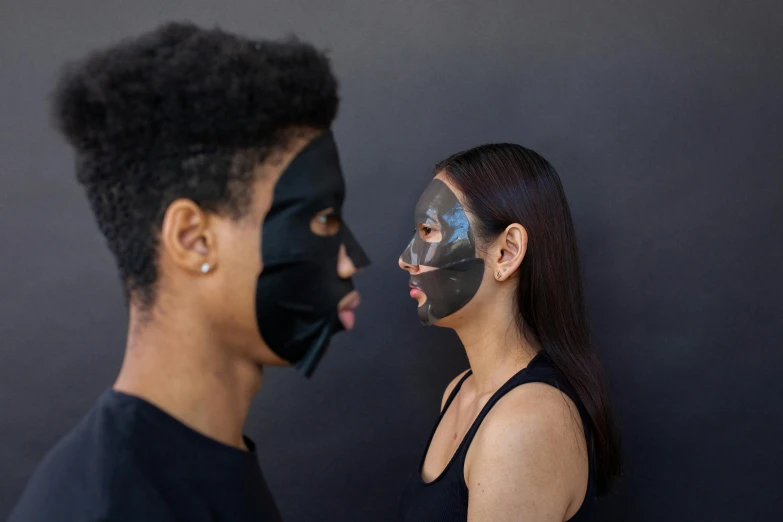 a man and a woman with black face masks, by Nina Hamnett, skin reflective metallic, profile image, symmetrical face and body, silicone skin