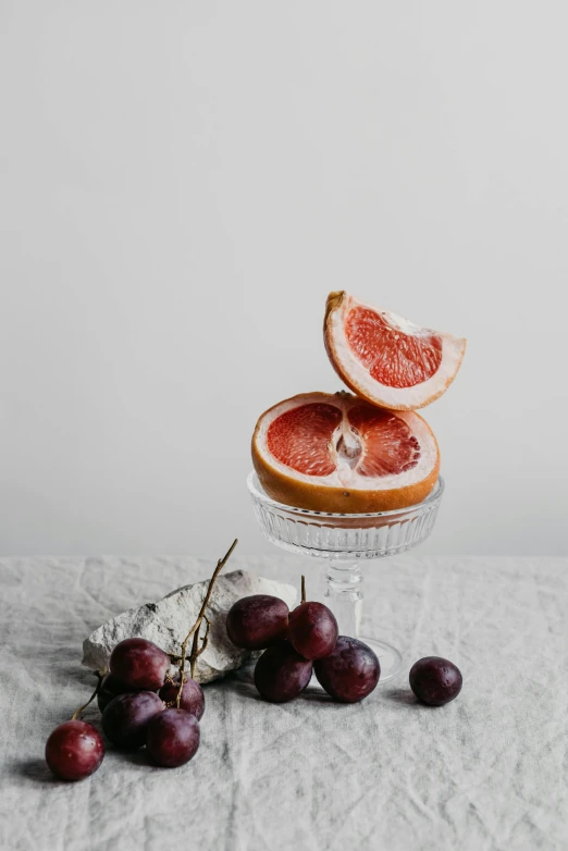 grapefruits and grapefruits on a table, by Carey Morris, pexels contest winner, red wine, white backdrop, linen, jovana rikalo