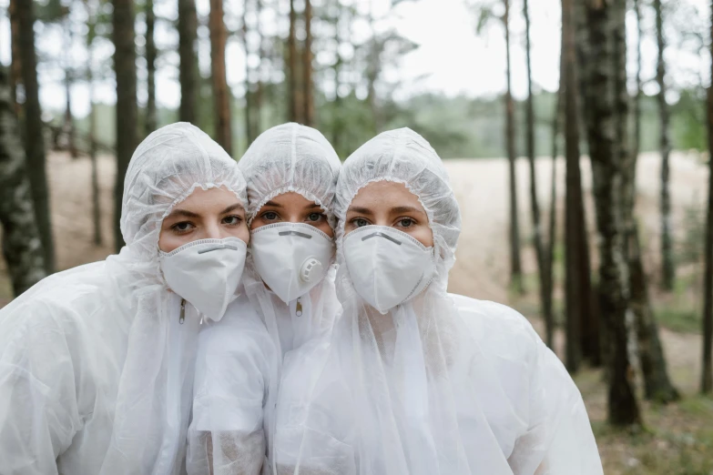 a couple of women standing next to each other in a forest, an album cover, by Emma Andijewska, pexels contest winner, staff wearing hazmat suits, three women, wearing a labcoat, construction