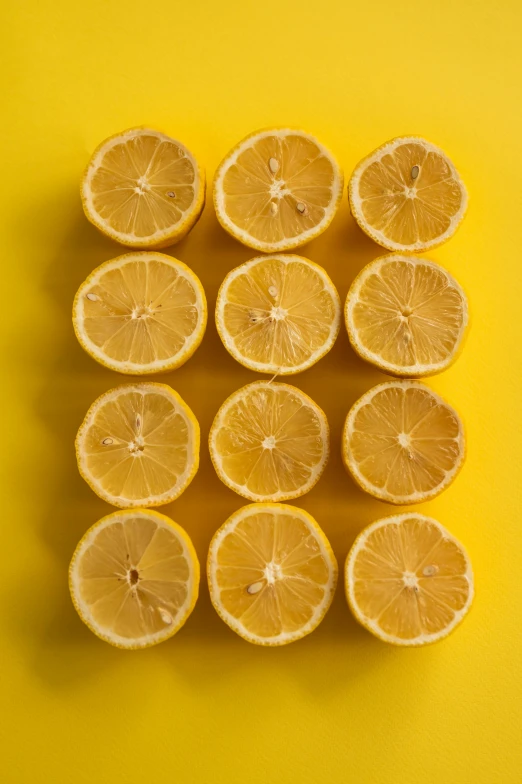 a group of lemons cut in half on a yellow background, laura watson, stacked image, 8l, vivid)