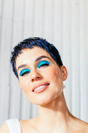 a close up of a person with blue eyes, an album cover, inspired by Glòria Muñoz, trending on pexels, antipodeans, pixie cut, bright blue, on clear background, looks like ebru şahin