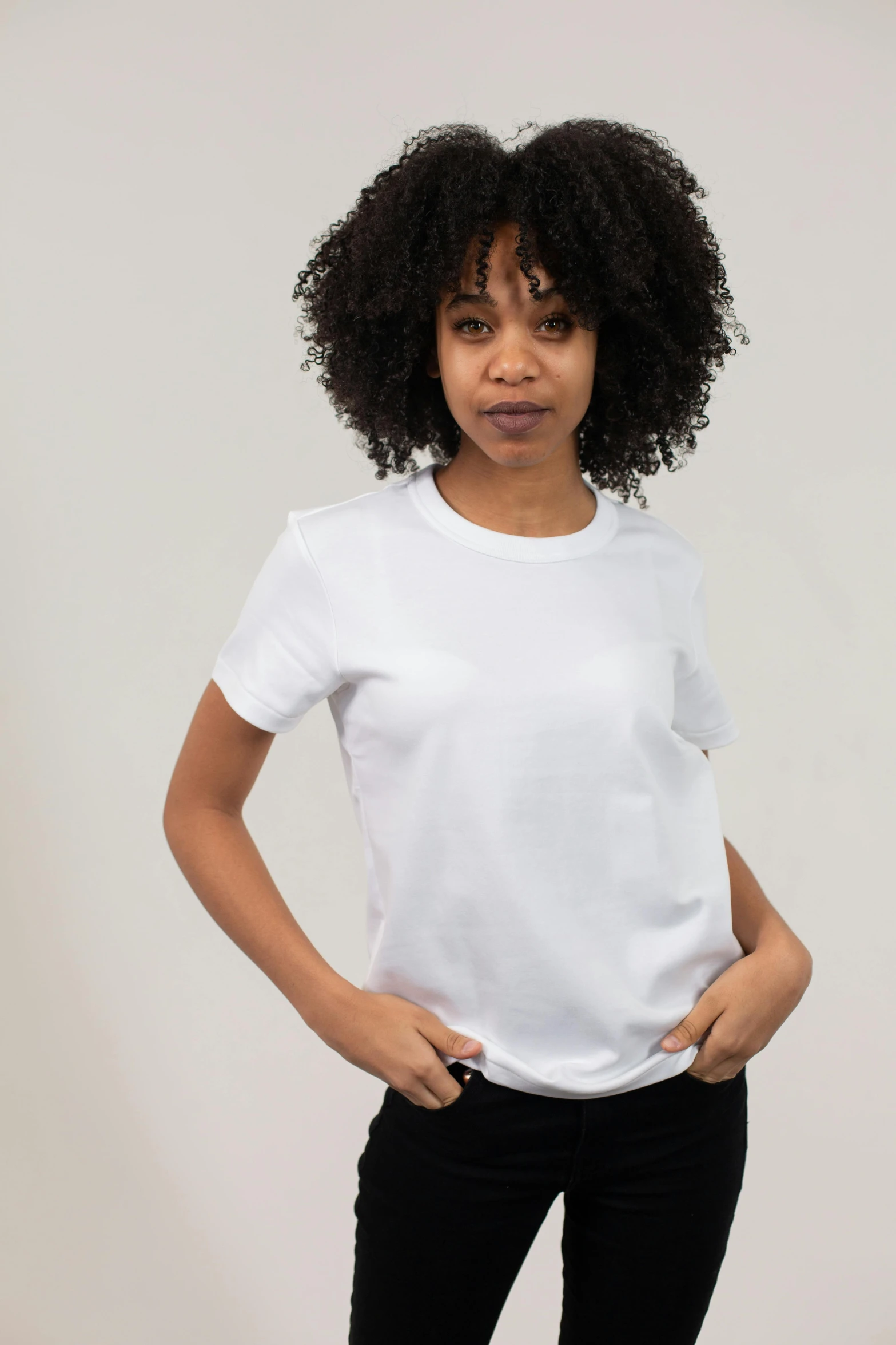 a woman standing with her hands in her pockets, a cartoon, trending on unsplash, plain white tshirt, thumbnail, portrait image, 8