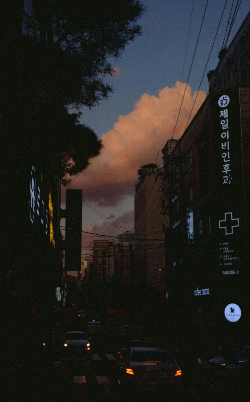 a street filled with lots of traffic next to tall buildings, an album cover, by Jang Seung-eop, unsplash, realism, night clouds, late afternoon, ((oversaturated)), patches of sky
