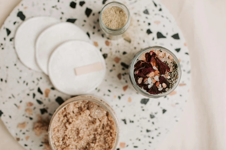 a couple of jars sitting on top of a table, by Emma Andijewska, trending on pexels, terrazzo, skincare, rice, diecut