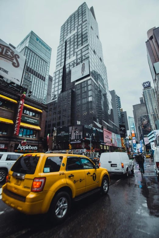 a city street filled with lots of traffic and tall buildings, raining, taxi, time square, instagram post