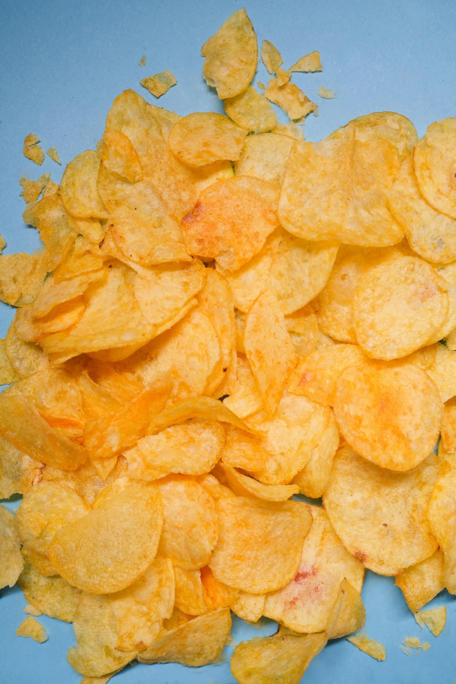 a pile of potato chips on a blue plate, trending on reddit, orange subsurface scattering, yellow flash, large)}], square