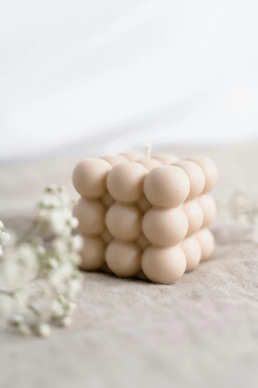 a bunch of balls sitting on top of a table, a marble sculpture, inspired by Isamu Noguchi, unsplash, white candles dripping wax, 4k polymer clay food photography, square, blonde cream